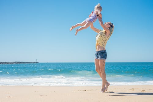Woman playing with her daughter at the beach